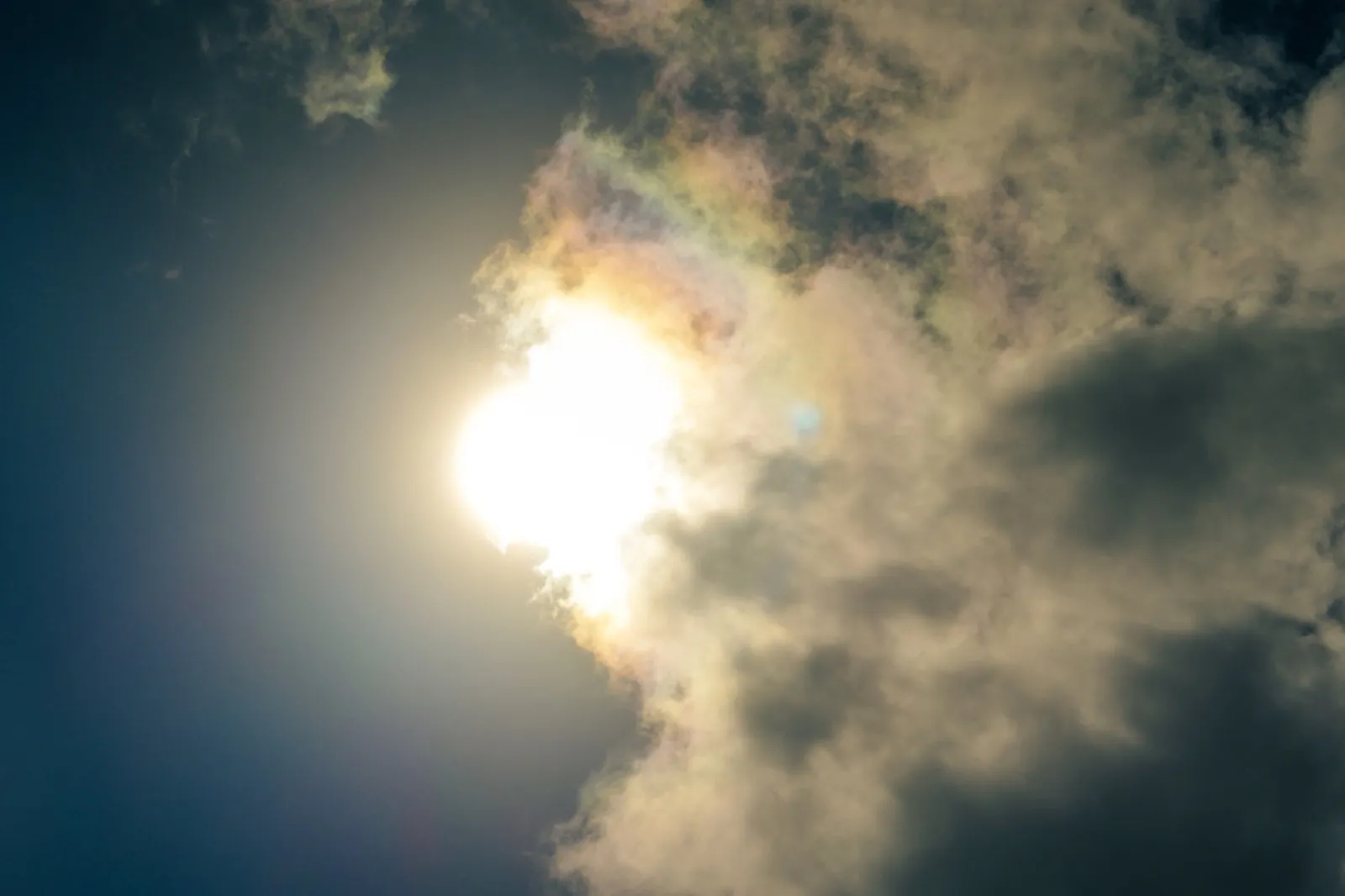 Bright sun shining through thick white cumulus clouds