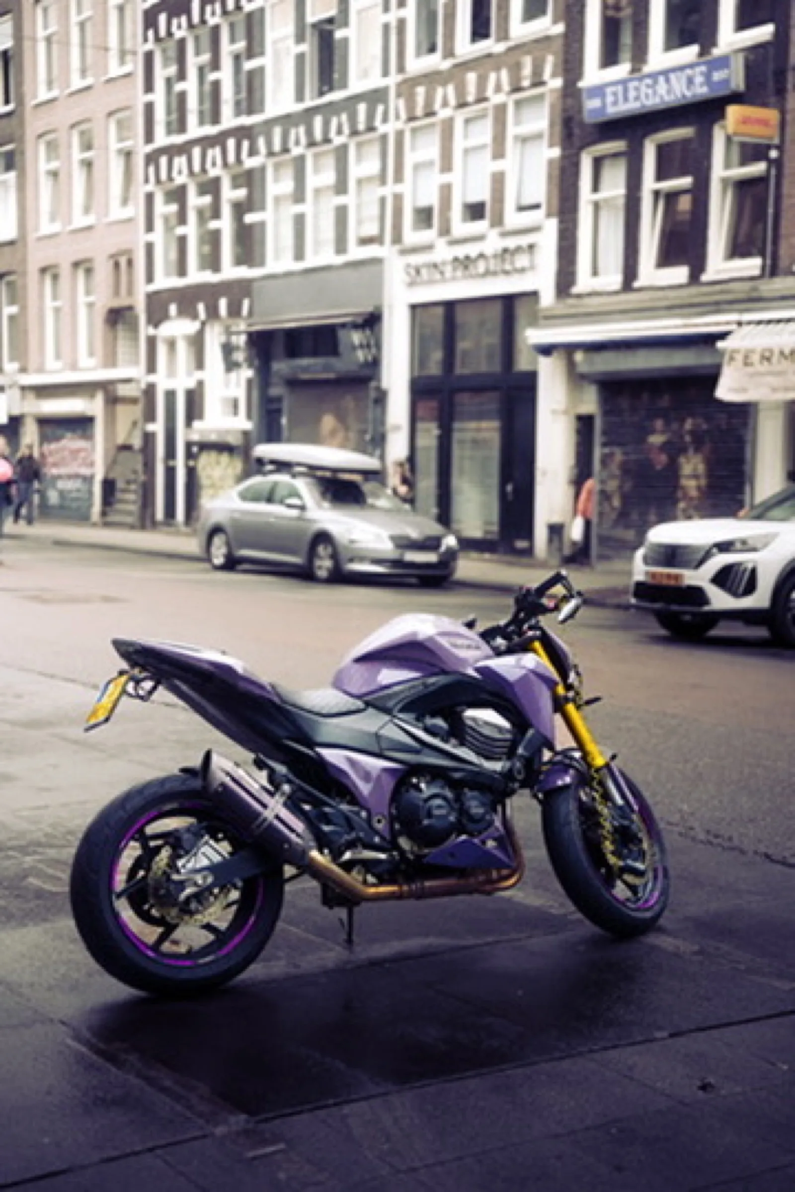 Purple motorcycle with yellow accents on city street