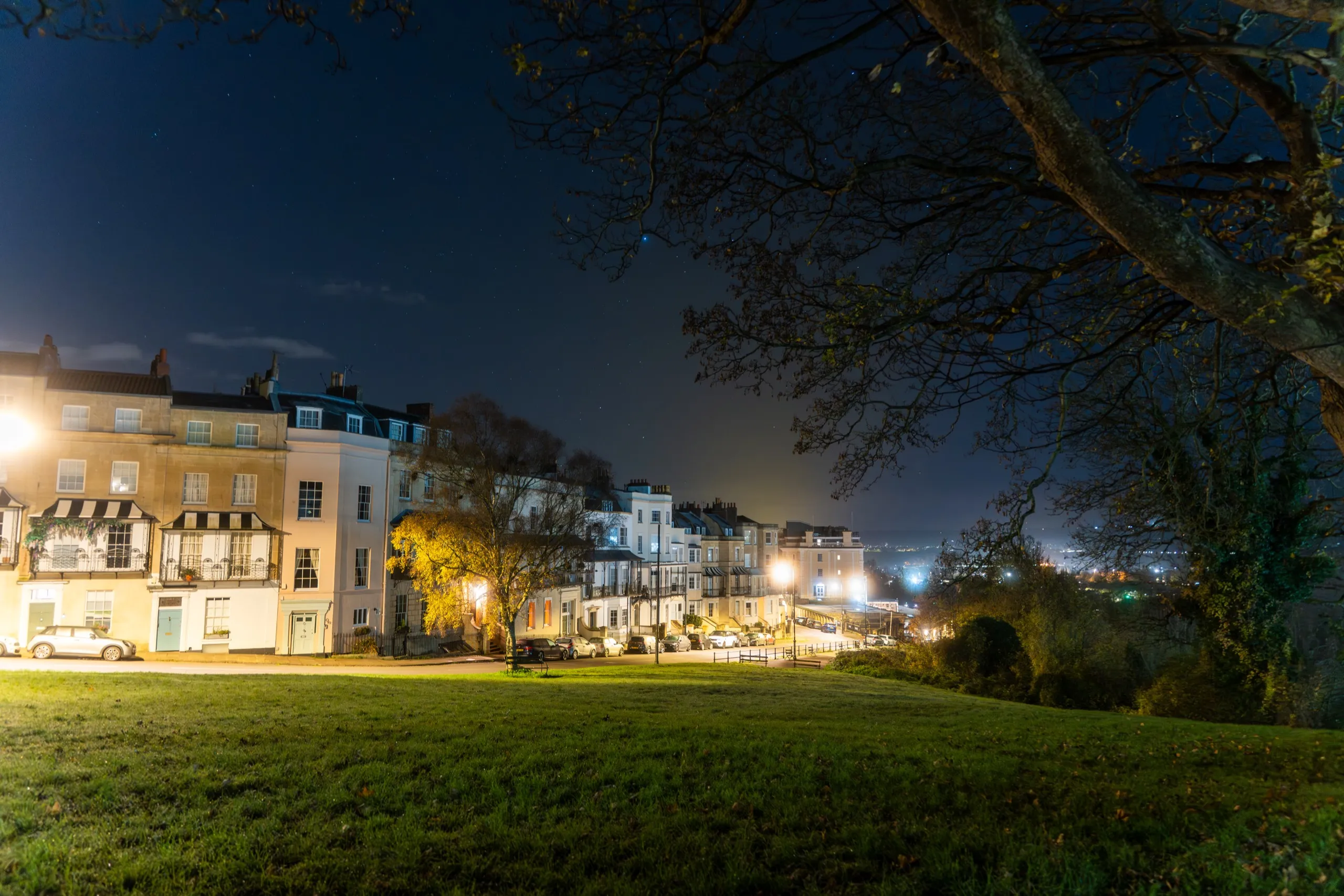 Georgian townhouses lit at night from a park
