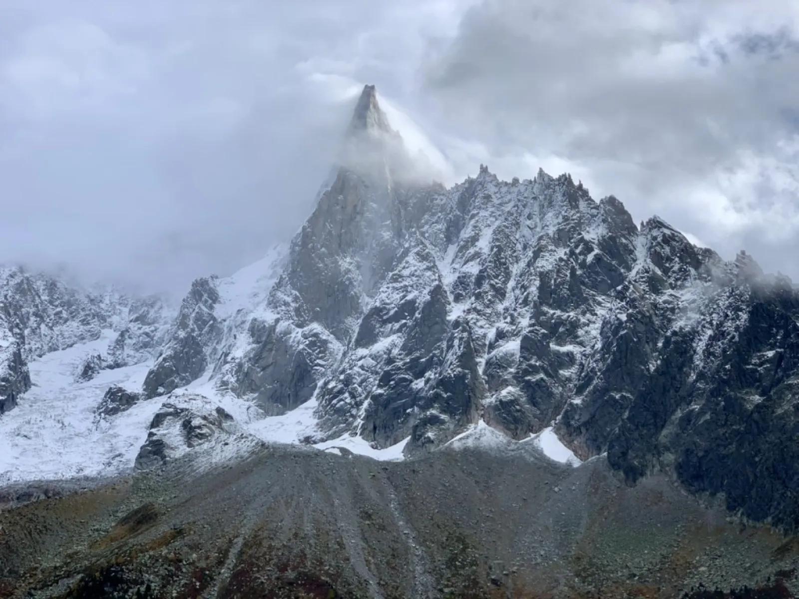 Jagged snow-covered mountain peak shrouded in clouds