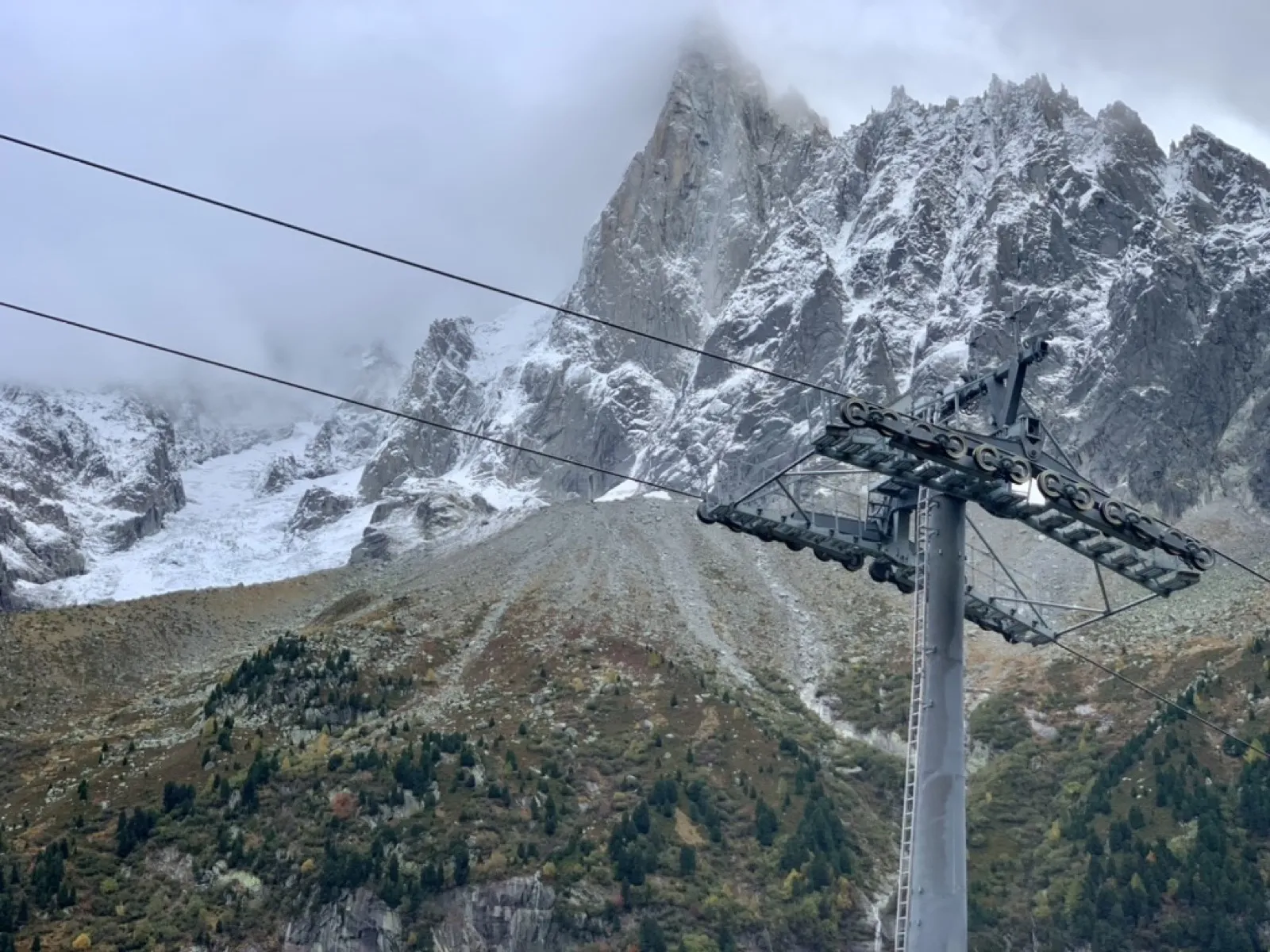 Mountain cable car with snowy peaks in background