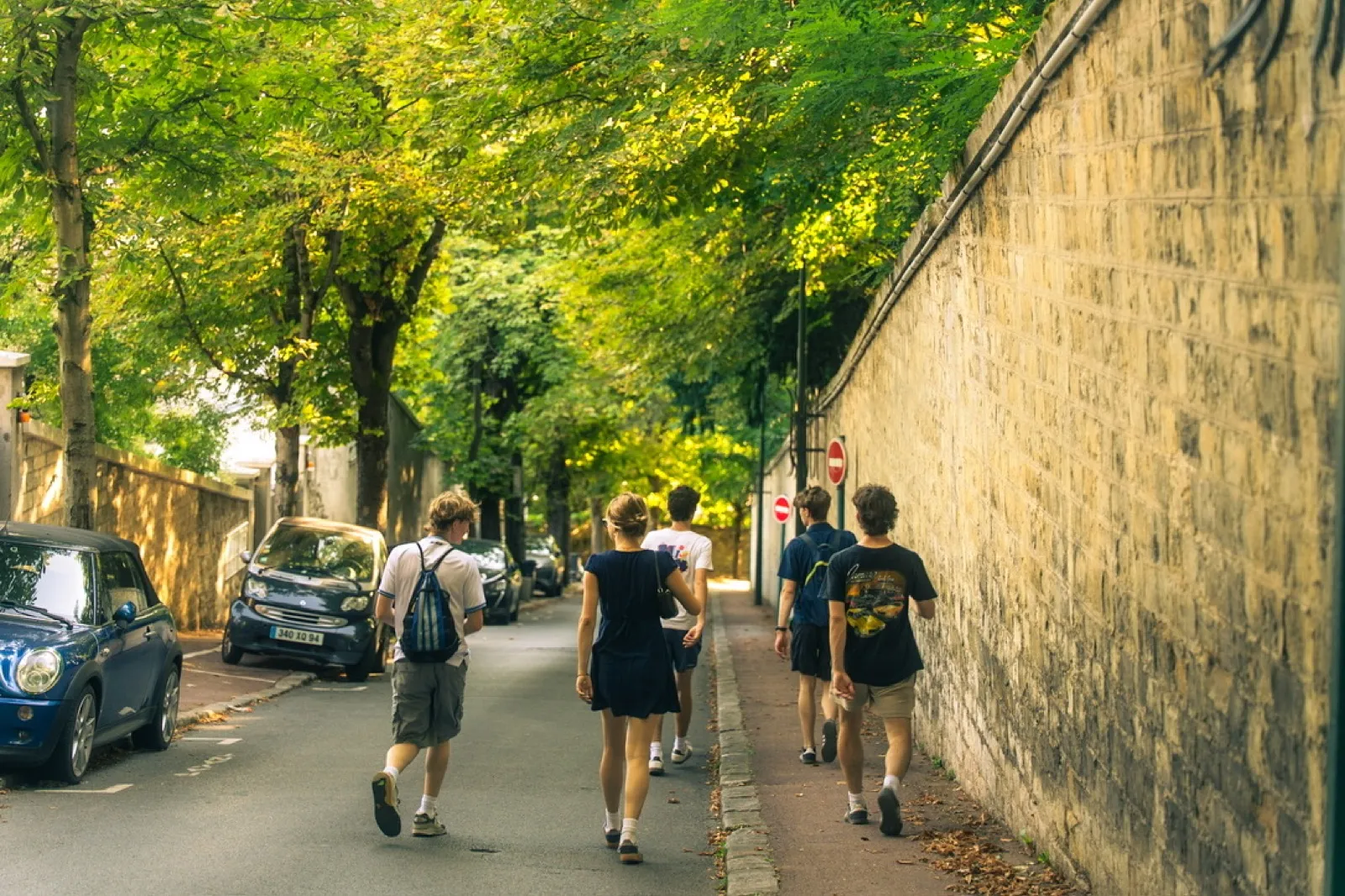 Runners jogging down tree-lined Parisian street