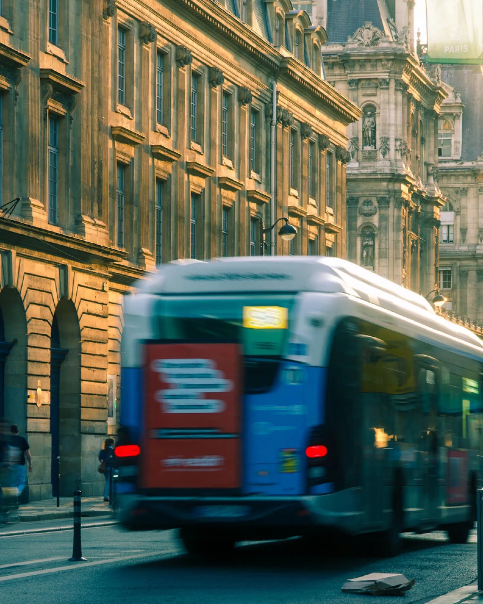 Blue tram passing ornate Parisian building facade