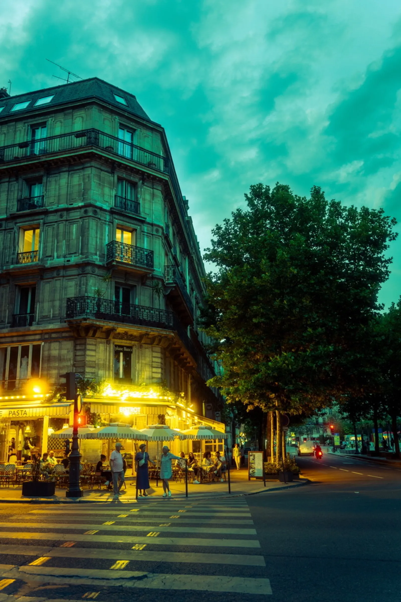 Lit corner café with turquoise sky and tree
