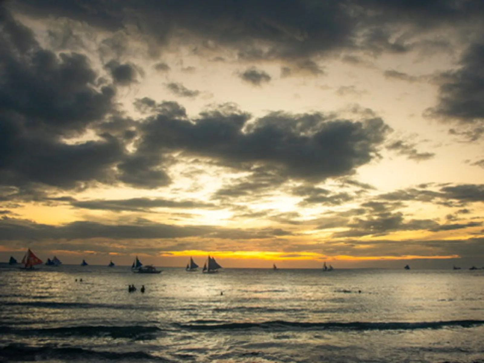 Sailboats on ocean at golden sunset