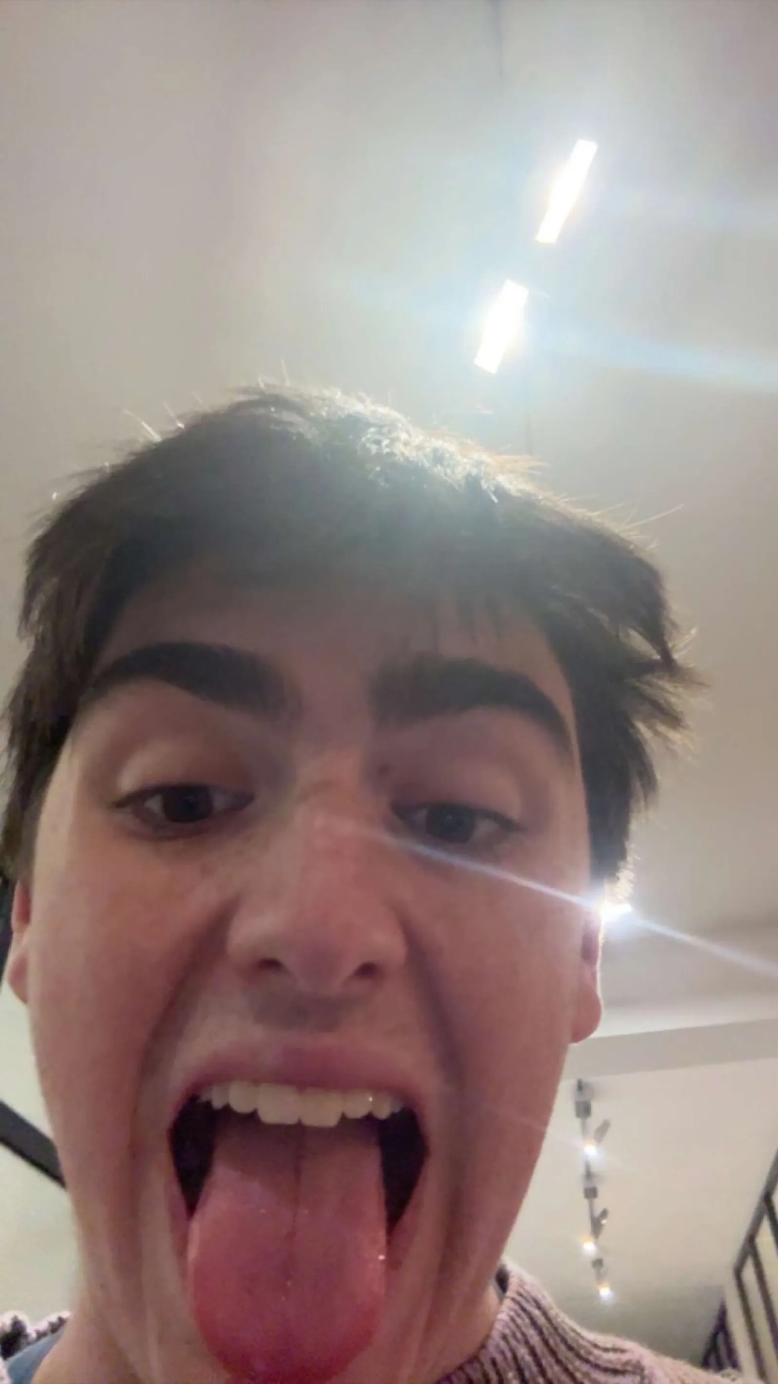 Man making silly face at camera indoors