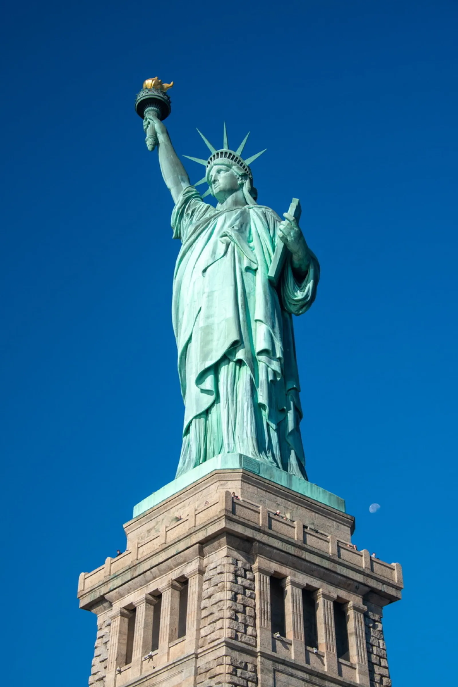Statue of Liberty on pedestal against blue sky
