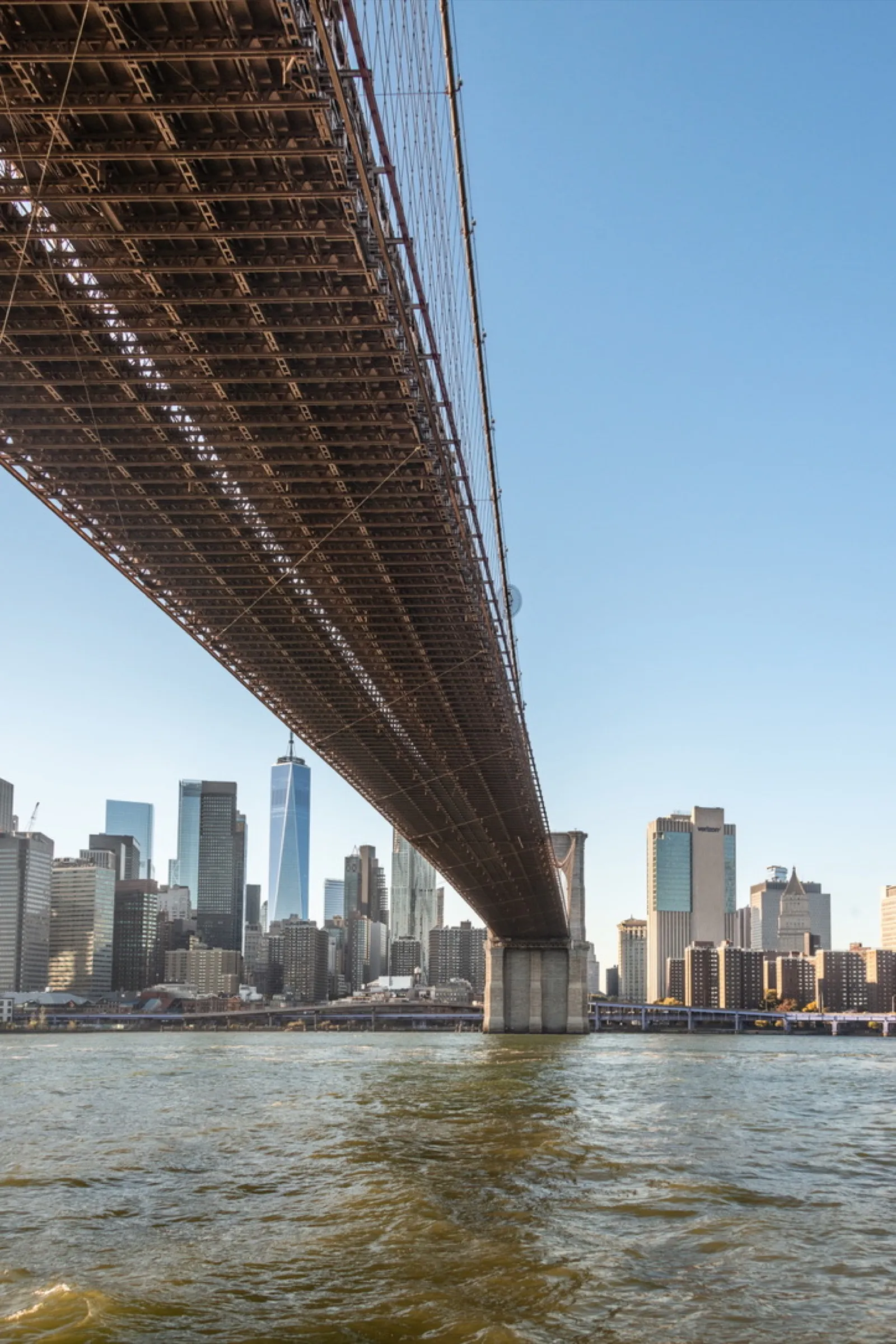 Bridge underside spanning blue river water