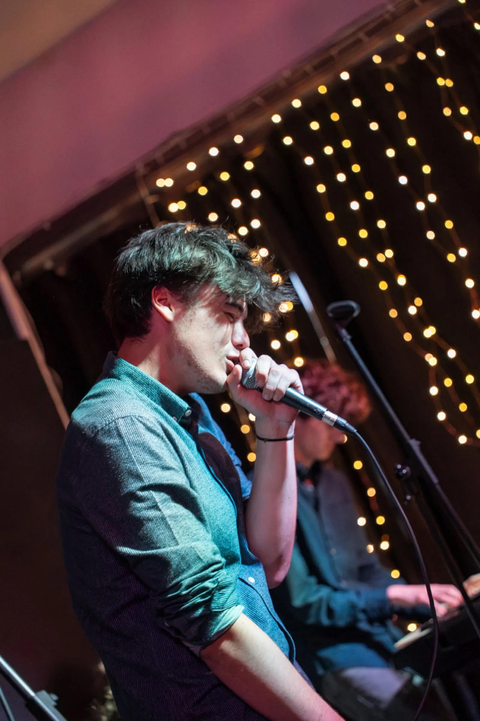 Singer performing with hand near microphone on stage