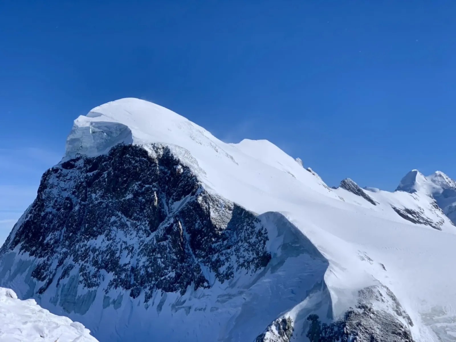Snow-covered Alpine peaks with clear blue sky